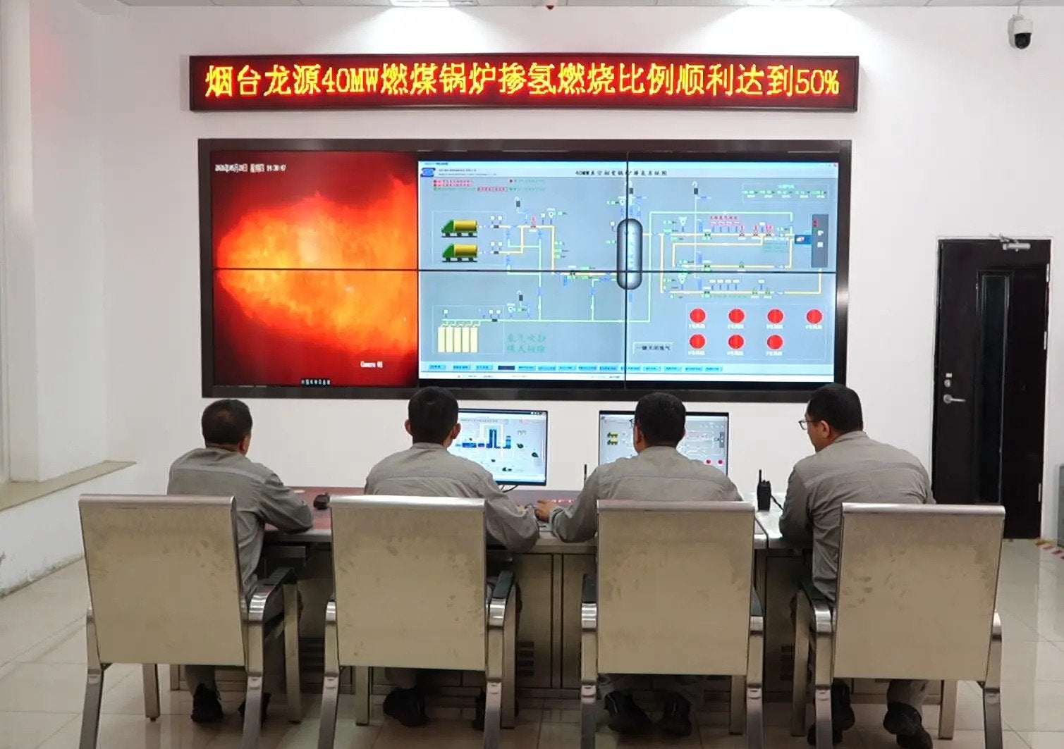 Technicians operating the 40MW pilot power plant during co-firing of 50% hydrogen and 50% coal. The dot-matrix display reads: “The hydrogen-blended combustion ratio of Yantai Longyuan's 40MW coal-fired boiler has successfully reached 50%.”